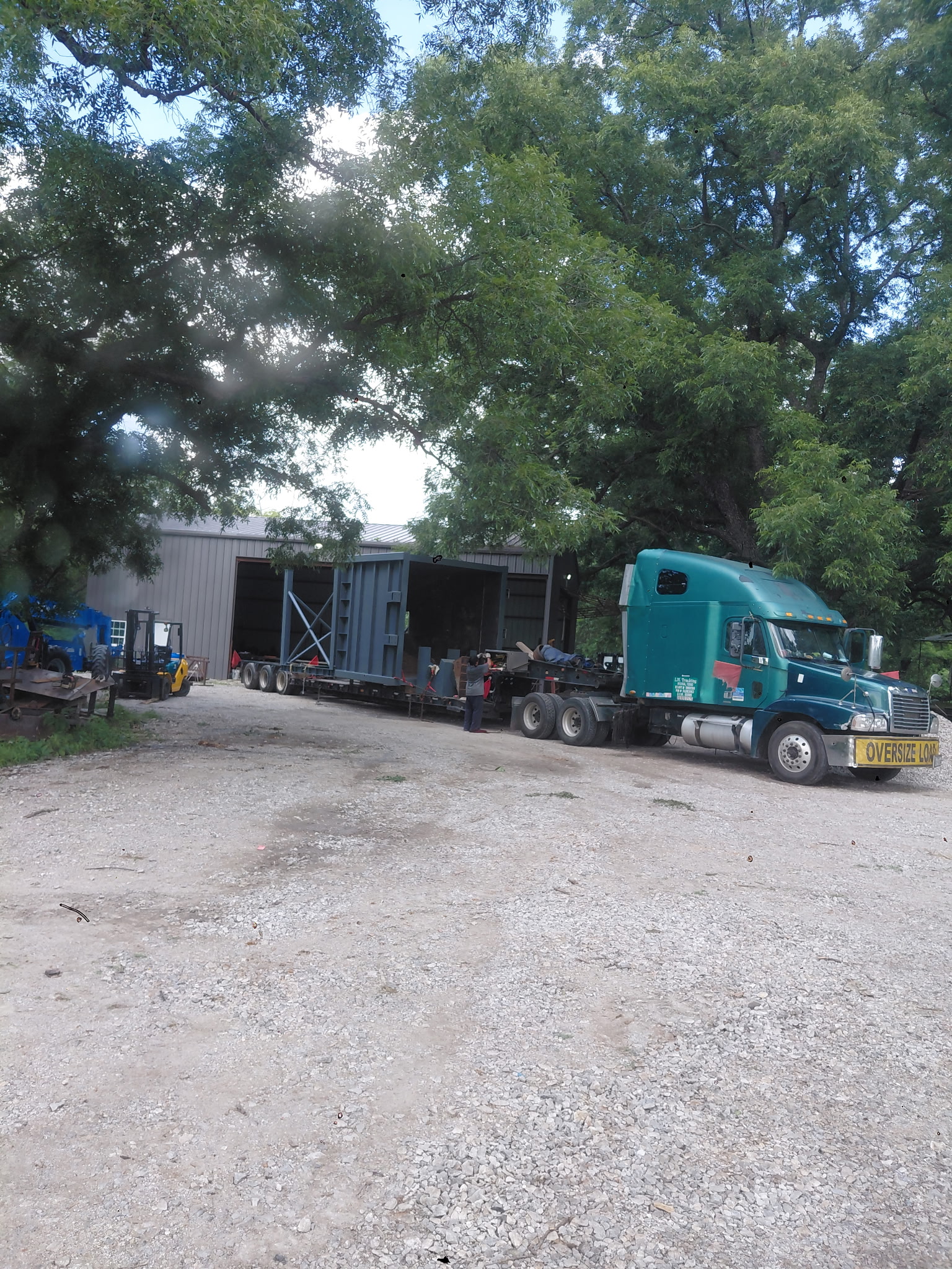 Flatbed truck delivering a fabricated steel enclosure to the shop