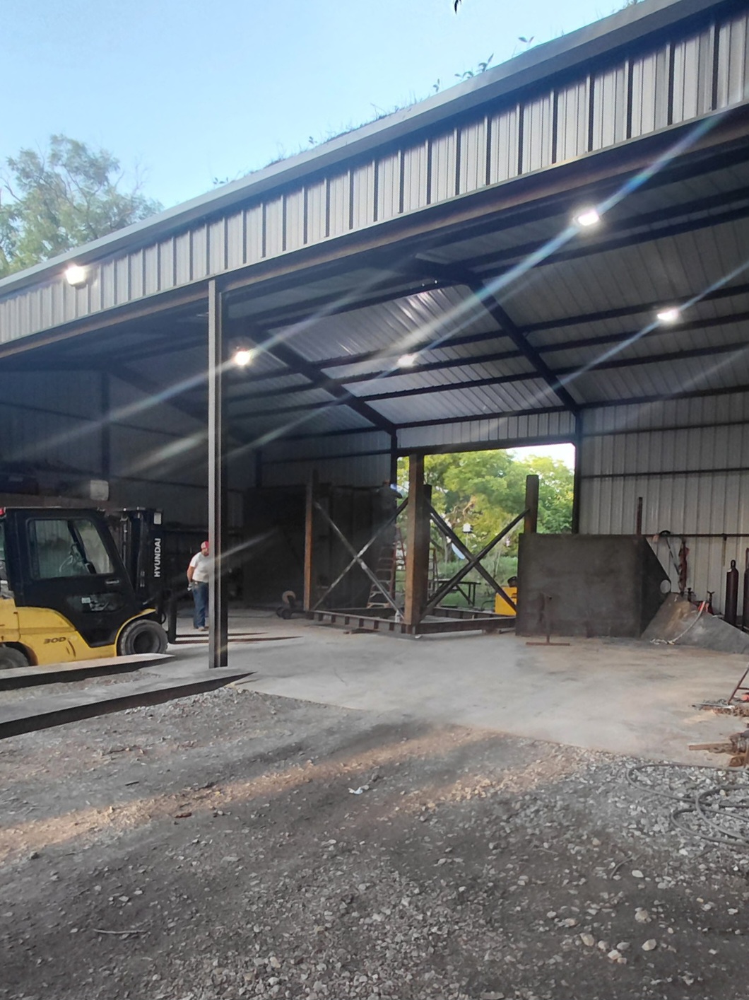 Open fabrication bay with forklift and steel framing under construction